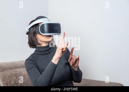 Teen Mädchen mit vr-Headset ist in der virtuellen Realität Cyberspace. Das Konzept des Metaverse, der virtuellen Realität, des virtuellen sozialen Universums. Zukünftige digitale te Stockfoto