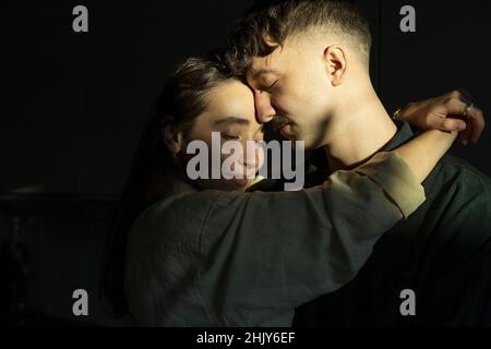 Junge Frau umarmt Freund zu Hause Stockfoto