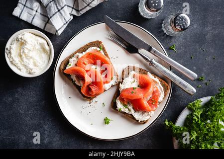 Roggen-Toast mit geräuchertem Lachs und Frischkäse, garniert mit Petersilie, Nahaufnahme Stockfoto