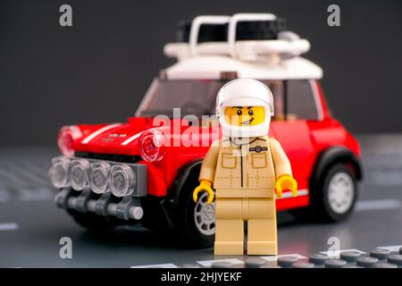 Tambov, Russische Föderation - 18. August 2019 Lego 1967 Mini Cooper S Rallye Fahrer Minifigur von LEGO Speed Champions gegen sein Auto auf einer Straße Basepla Stockfoto