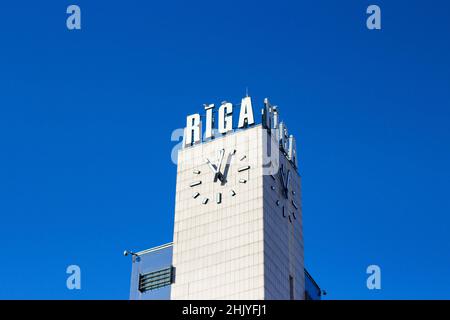 Uhrenturm des Bahnhofs Riga. Hochwertiges Foto, blauer Himmel auf einem Hintergrund Stockfoto