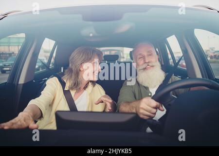 Foto von fröhlichen reifen Paar Gespräch Fahrt Rant Auto Lenkrad sorgfältige Wochenend-Urlaub im Freien Stockfoto