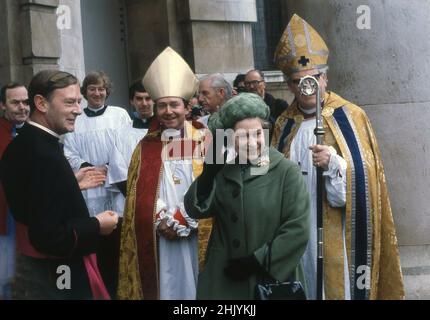 1977, historisch, hob ihre Majestät Königin Elizabeth II. Ihre Hand, um die Zuschauer vor der St. Pancras Kirche in der Euston Rd, London, England, Großbritannien, zu würdigen, die mit hochrangigen Geistlichen, darunter zwei Bischöfe in ihren religiösen Gewändern, Gewändern und Hüten, im Rahmen ihrer Silbernen Jubliee-Feierlichkeiten standen. Stockfoto