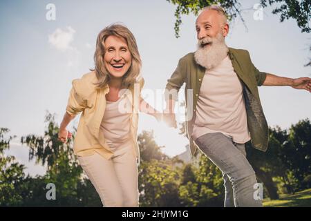 Foto von verrückten alten grauen Haaren Paar treffen Abenteuer tragen Shirts Jeans draußen verbringen Freizeit Stockfoto