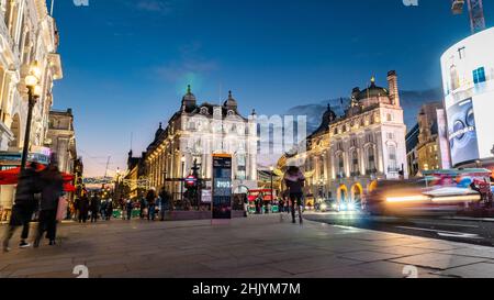 Piccadilly Circus, London, England. Eine kreative Langzeitaufnahme des Touristenviertels im Zentrum von London mit verschwommenem Verkehr und Fußgängern. Stockfoto
