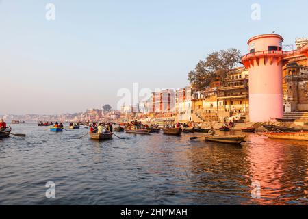 Touristen in Ruderbooten erkunden Fluss Ganges Ufer Ghats Panorama: Panoramablick von Jalasen Ghat in Varanasi, Uttar Pradesh, Nordindien Stockfoto