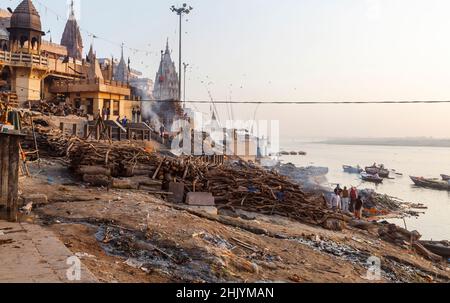 Auf Manikarnika Ghat in Varanasi (ehemals Banaras oder Benares), einer Stadt am Fluss Ganges in Uttar Pradesh, Nordindien, brennen Scheiterhaufen Stockfoto