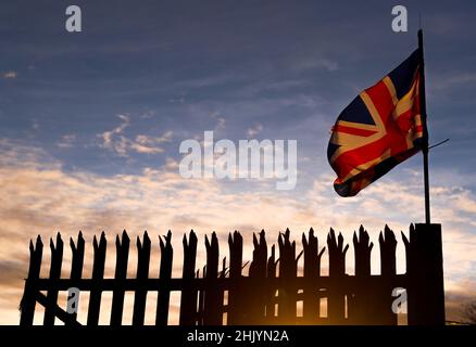 Die Sonne geht über dem Osten von Belfast auf, während die Union Flag im Wind flattert. Stockfoto