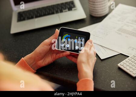 Nahaufnahme Einer Frau Mit Intelligentem Energiemessgerät In Der Küche Messung Des Strom- Und Gasbedarfs Mit Rechnungen Mit Rechner Stockfoto