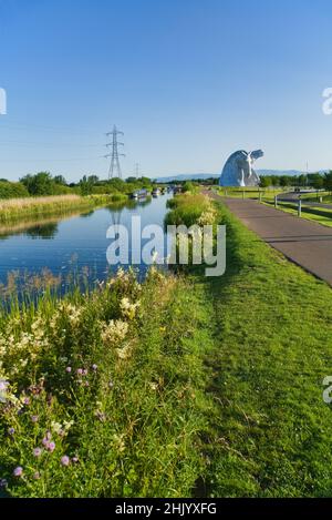 Die Kelpies mit hellen und bunten wilden Blumen am Forth und Clyde Canal Ufer. Helix Public Park, Falkirk, Stirlingshire, Central, Schottland, VEREINIGTES KÖNIGREICH. Stockfoto