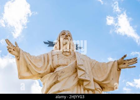 Corazon de Jesus religiöse Statue über Puerto de Mazarron, Murcia, Spanien. Abschuppung und Verwitterung. Vogelkot läuft den Kopf hinunter Stockfoto