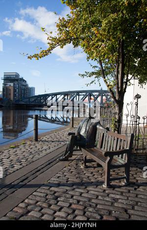 Blick auf Leith, Edinburgh, Schottland, inklusive einer Statue von Sandy Irvine Robertson OBE, die auf einer Bank am Wasser saß Stockfoto