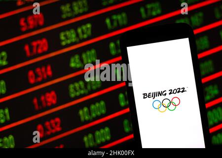 Polen. 01st. Februar 2022. Auf dieser Fotolabbildung ist ein Logo der Olympischen Winterspiele 2022 in Peking zu sehen, das vor den Börsencharts zu sehen ist. Kredit: SOPA Images Limited/Alamy Live Nachrichten Stockfoto