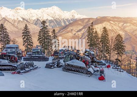 Parken auf einer Piste Schneeräumgeräte für ein Skigebiet. Schneepflügen Bulldozer Grooming für Ski- und Snowboardurlaub am Berg Stockfoto