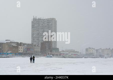 Wandern auf Margate Main Sands in der Nähe von Arlington House und Dreamland im Schnee, Margate, Kent Stockfoto