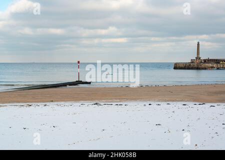 Ein eingeflügelter Kajakfahrer im Meer in der Nähe des Harbour Arms und des Margate Main Sands im Schnee, Margate, Kent, Großbritannien Stockfoto