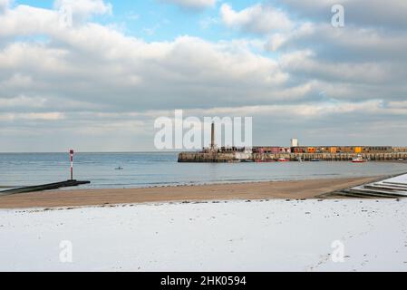 Ein eingeflügelter Kajakfahrer im Meer in der Nähe des Harbour Arms und des Margate Main Sands im Schnee, Margate, Kent, Großbritannien Stockfoto