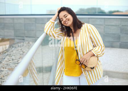 Urban Portrait von schönen glücklich plus size latin Frau 30-35 Jahre alt lächeln mit geschlossenen Augen und genießen Sie den Sommer Stockfoto