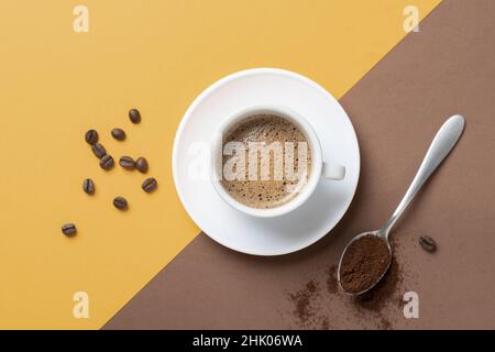 Flache Lay Zusammensetzung der Tasse Kaffee auf braunem und gelbem Hintergrund. Stockfoto