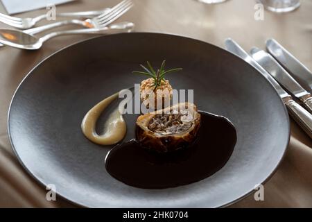 Kochen auf einem schwarzen Teller Stockfoto