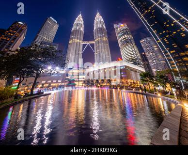 Kuala Lumpur, Malaysia - Januar 2022: Die Petronas Towers und das Suria Einkaufszentrum vom KLCC Park - weltberühmte Wolkenkratzer in Kuala Lumpur City Cen Stockfoto