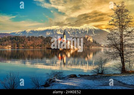 Bleder See, Slowenien. Schöner Bergsee mit kleiner Wallfahrtskirche bei Sonnenuntergang. Stockfoto