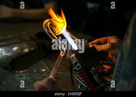 Verarbeitung Glasbläserherstellung . Feuer erhitzt Glasrohling mit Glasbläserbrenner. Handgefertigte Glashütten Stockfoto