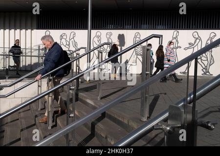 Am 31st. Januar 2022, in London, England, laufen Londoners an einem thematischen Wandgemälde vorbei, das Piktogrammformen von Fußgängern zeigt. Stockfoto