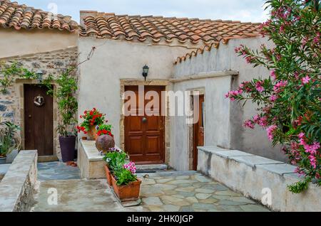 Schöne traditionelle alte Häuser mit mittelalterlicher Architektur und schöner Dekoration mit Blumentöpfen auf der Insel Monemvasia, Griechenland Stockfoto