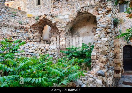 Antike mittelalterliche Ruinen eines Steingebäudes aus byzantinischer Zeit. Schöne Architektur mit großen Bögen. Alte Festung in Monemvasia Castle Town, Griechenland Stockfoto