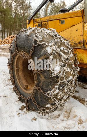 Nahaufnahme der Winterketten auf dem gelben Holzfäller Stockfoto