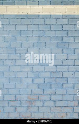 Blau gemalte Ziegelwand mit weißem Rand auf der Oberseite Stockfoto