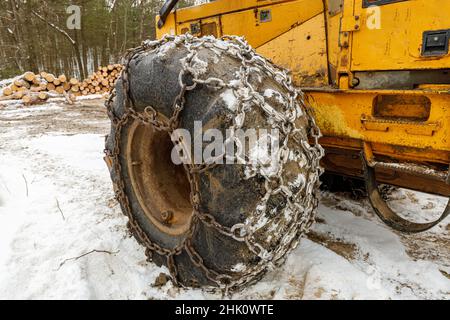 Nahaufnahme der Winterketten auf dem gelben Holzfäller Stockfoto