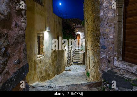 Schöne Allee in der mittelalterlichen Burgstadt Monemvasia Insel, Griechenland bei Nacht. Malerische Straße mit Steinhäusern aus byzantinischer Zeit. Stockfoto