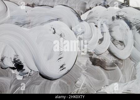 Weiße Malstriche auf einem Schaufenster, abstrakter Hintergrund oder Textur Stockfoto