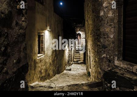 Schöne Allee in der mittelalterlichen Burgstadt Monemvasia Insel, Griechenland bei Nacht. Malerische Straße mit Steinhäusern aus byzantinischer Zeit im Sepia-Stil. Stockfoto