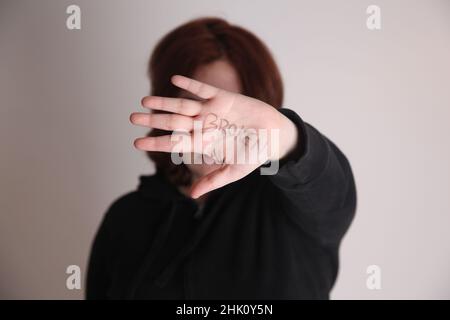 Frau im Studio mit gebrochenem Wort auf der Hand Stockfoto
