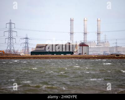 Isle of Grain, Kent, Großbritannien. 1st. Februar 2022. Steigende britische Energiepreise. Schornsteine und Pylone aus dem Kraftwerk auf der Isle of Graint, Kent Gestern aus Lower Halstow, Kent. Kredit: James Bell/Alamy Live Nachrichten Stockfoto