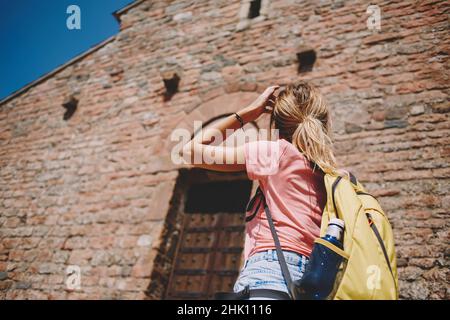 Nicht erkennbare weibliche Touristen, die das alte Gebäude betrachten Stockfoto