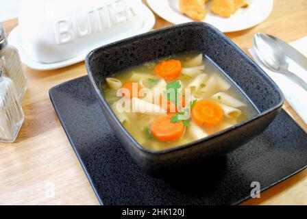 Vegane Penne-Gemüsesuppe in einer quadratischen Schüssel Stockfoto