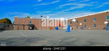 Leerer Schulasphaltplatz in Ridgefield, NJ, USA. Mit Basketball-Backboards und blauem Himmel. Stockfoto