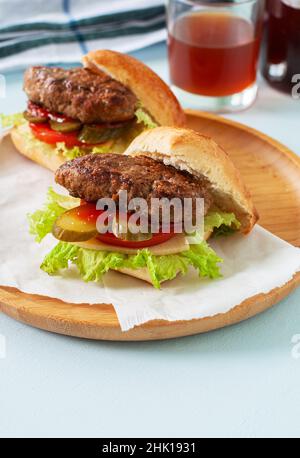 Hausgemachte Burger auf einem Holzteller. Nahaufnahme. Stockfoto