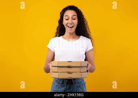 Happy Latin Lady Hält Pizzakisten Im Studio Stockfoto