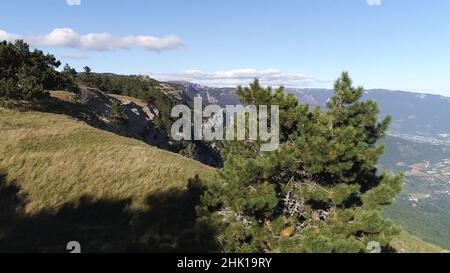 Malerische Landschaft der Bergkette Hang und Tal mit grünen Bäumen gegen den blauen Himmel mit schönen Wolken im Sommer Tag bedeckt. Unglaublich Stockfoto