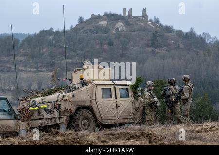 Hohenfels, Deutschland. 27th Januar 2022. US-Soldaten stehen während der internationalen Militärübung 'Allied Spirit 2022' auf dem militärischen Trainingsgelände in Hohenfels neben einem High Mobility Multipurpose Wheeled Vehicle (HMMWV). Mit Hubschraubern, Panzern und Infanterie trainieren Streitkräfte aus mehr als zehn Ländern auf einem Trainingsgelände für Notfälle. Quelle: Armin Weigel/dpa/Alamy Live News Stockfoto