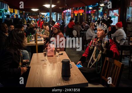 London, Großbritannien. 1. Februar 2022. Ein Mann, der als Geldgott gekleidet ist, rast sich von den Feierlichkeiten in Chinatown am Abend des chinesischen Neujahrs aus, während das Jahr des Tigers offiziell beginnt. Die Feierlichkeiten in Chinatown werden in diesem Jahr aufgrund der Pandemie zurückgeschraubt, aber die Restaurants hoffen, dass die Geschäfte jetzt wieder aufgenommen werden, da die Beschränkungen von Plan B Omicron durch die britische Regierung gelockert wurden. Kredit: Stephen Chung / Alamy Live Nachrichten Stockfoto