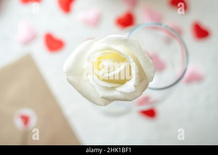 Valentinskarte mit weißer Rose und Liebesumschlag Stockfoto