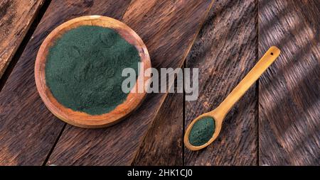 Frisches Spirulina-Pulver in einer Schüssel auf einem hölzernen Hintergrund Stockfoto