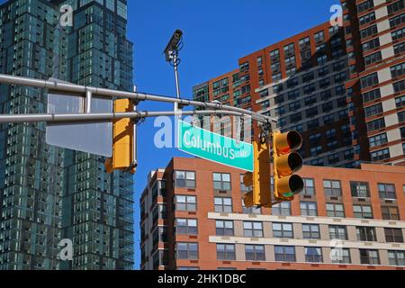 Grünes großes Columbus Drive-Schild, das an einem Bogenmast zwischen den Ampeln in den Straßen der Innenstadt von Jersey City hängt Stockfoto