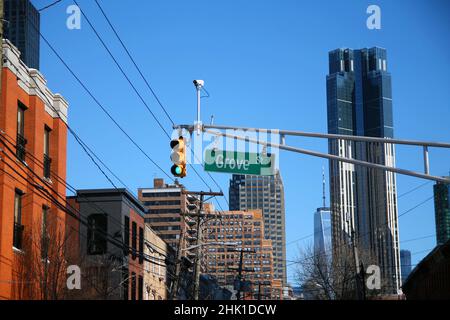 Grünes großes Grove Street-Schild, das an einem Bogenmast zwischen den Ampeln in den Straßen der Innenstadt von Jersey City hängt Stockfoto